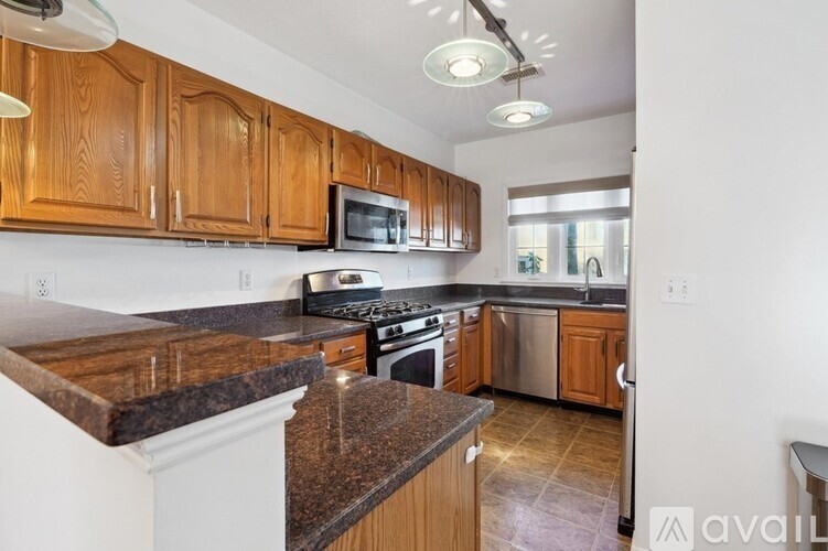 A kitchen with wooden cabinets and granite countertops.
