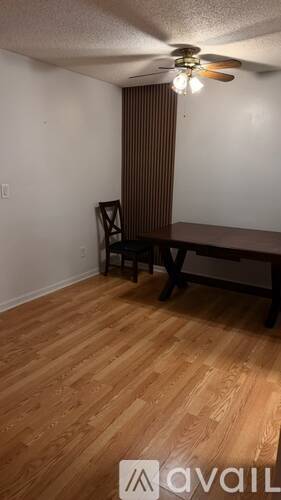 A room with a wooden floor and a table with two chairs.