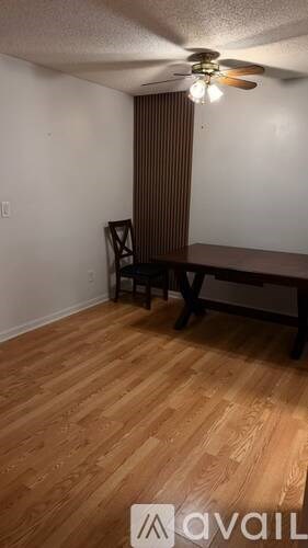 A room with a wooden floor and a table with two chairs.