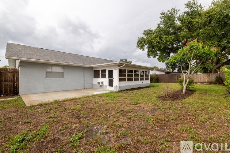 A house with a grey roof and a tree in front of it.
