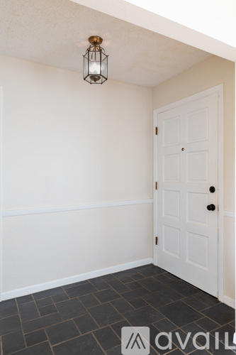 A white door is in a room with a lantern hanging from the ceiling.