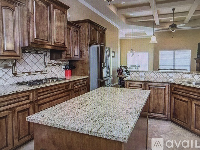 A kitchen with wooden cabinets and granite countertops.