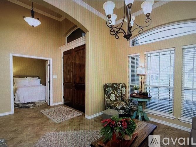A bedroom with a large bed and a chandelier.