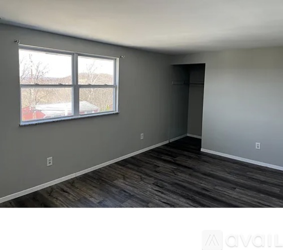 A room with a window and a door is available for rent.