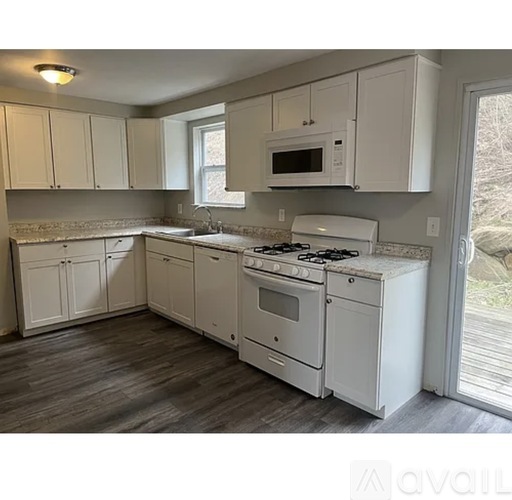 A kitchen with white appliances and cabinets.