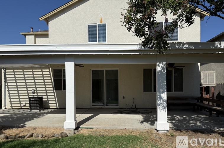 A house with a white exterior and a covered patio area.