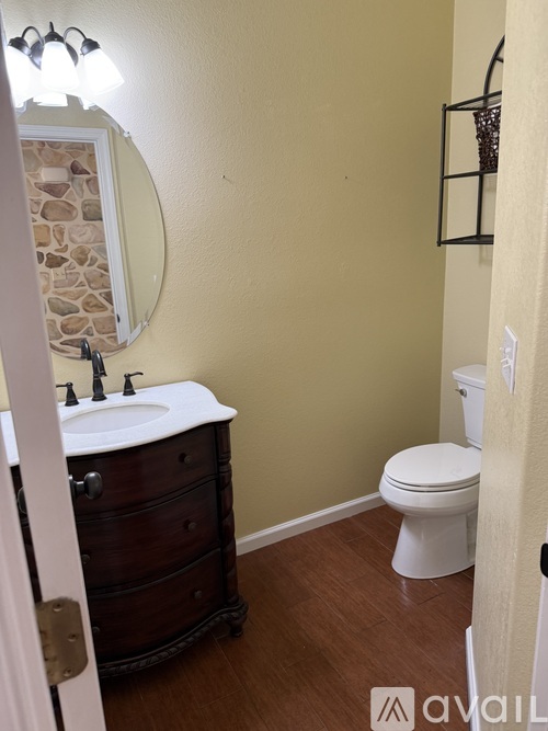 A bathroom with a stone wall and a white toilet.