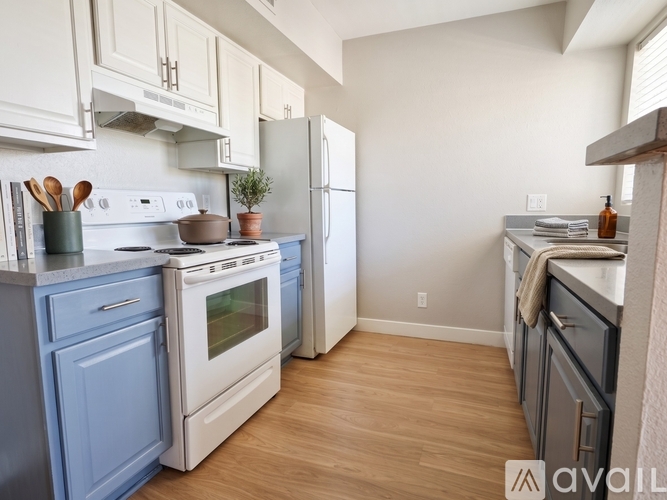 A kitchen with a white stove top oven and a white refrigerator.