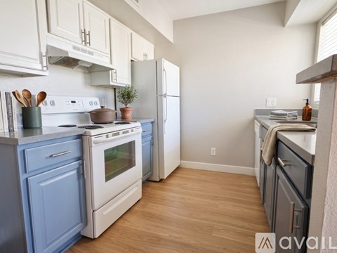 A kitchen with a white stove top oven and a white refrigerator.