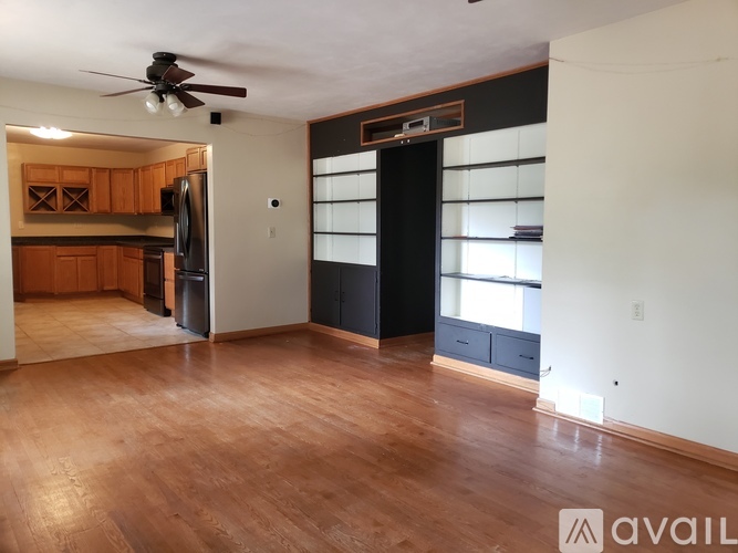 A room with wooden floors and a ceiling fan.