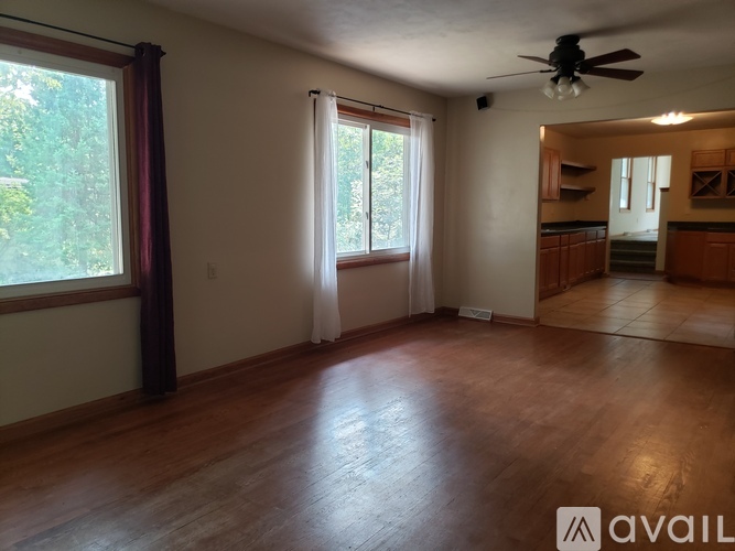 A room with wooden floors and a ceiling fan.
