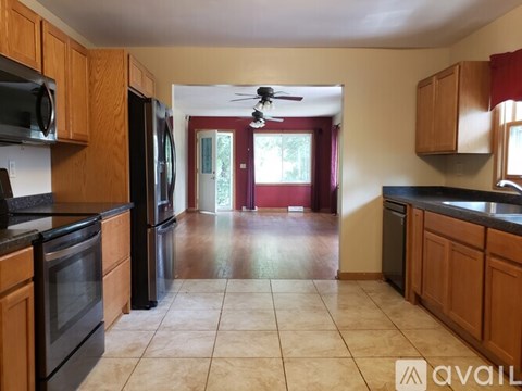 A kitchen with wooden cabinets and black appliances.