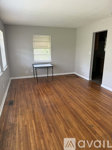 A room with wooden flooring and a table in it.