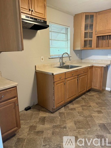 A kitchen with wooden cabinets and a tiled floor.