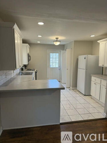 A kitchen with white cabinets and a large island.