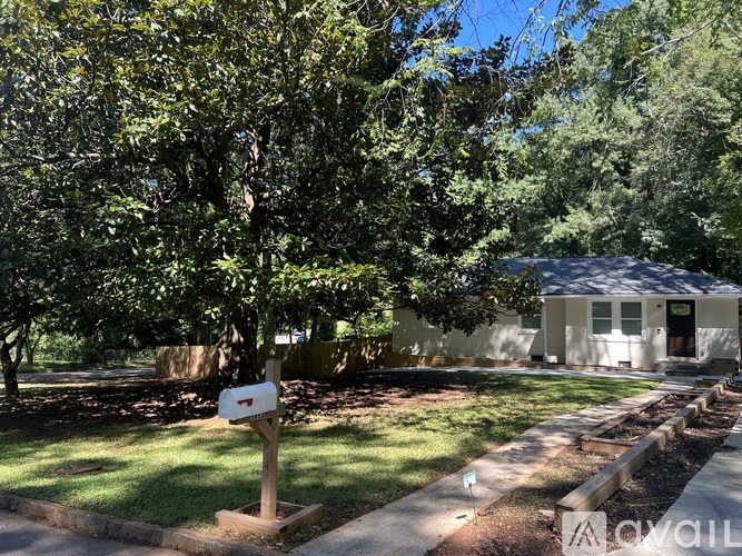 A tree-lined street with a mailbox and a house in the background.