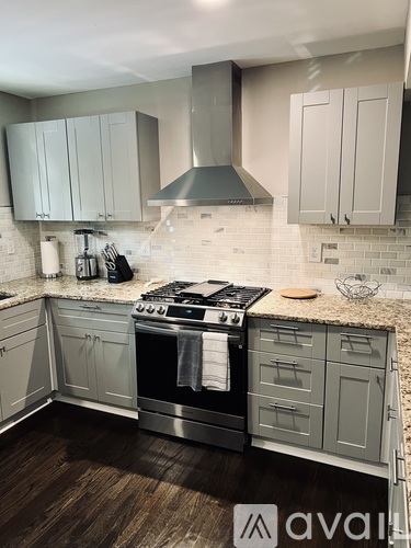 A kitchen with a stove top oven and a hood.