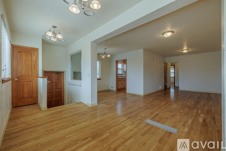 A spacious room with wooden floors and white walls.