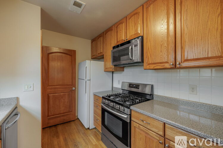 A kitchen with wooden cabinets and a black microwave above the stove.