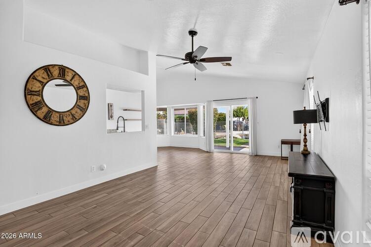 A living room with a wood floor and a ceiling fan.