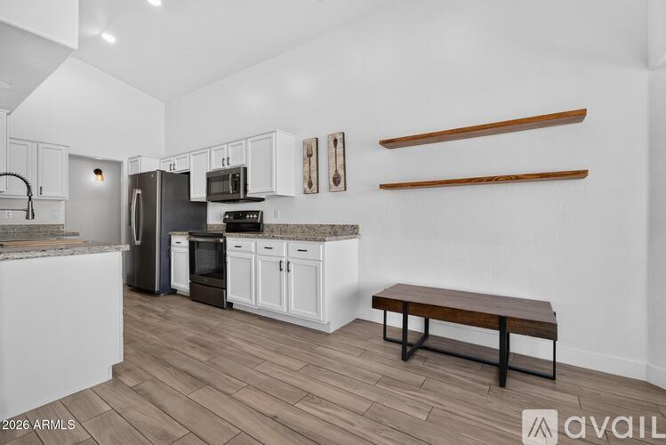 A kitchen with white cabinets and a wooden bench.