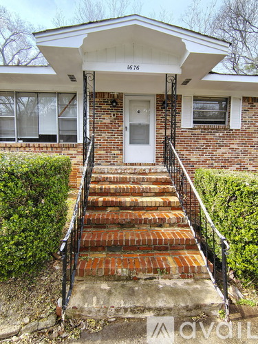 A house with a white door and a brick staircase leading to the front door.
