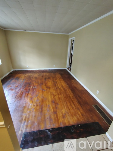 A room with wooden flooring and a white ceiling.