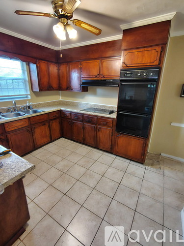 A kitchen with wooden cabinets and a tile floor.