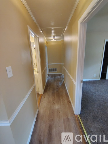 A long hallway with a carpeted floor and white walls.