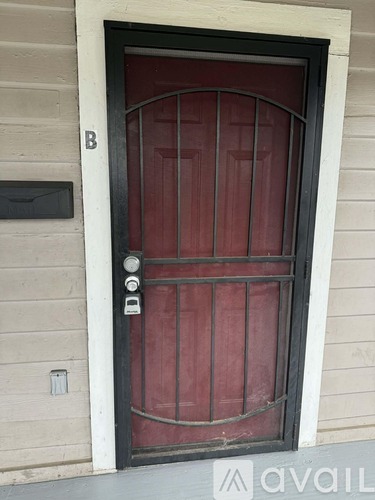 A red door with a black handle and a letter B above it.