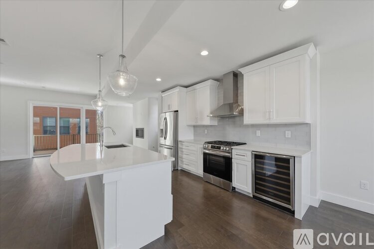 A modern kitchen with white cabinets and stainless steel appliances.