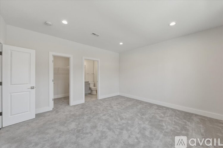 A spacious room with carpeted floor and white walls.