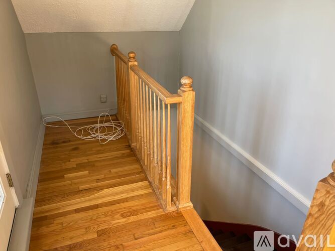 A wooden staircase with a white wall on the side.