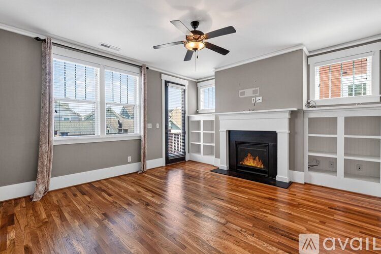 A living room with a fireplace and a ceiling fan.
