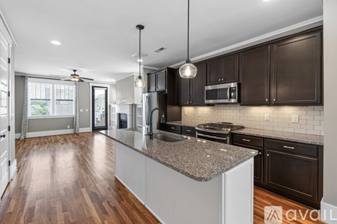 A modern kitchen with dark brown cabinets and a granite countertop.