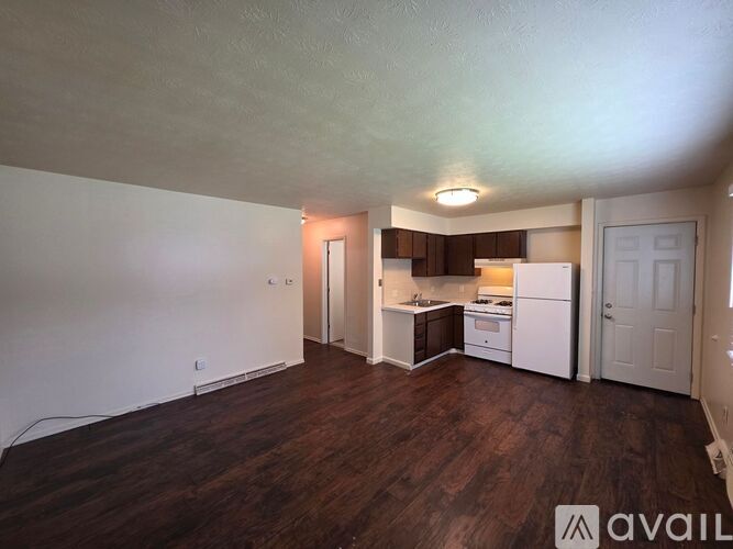 A kitchen area with white appliances and a white door.