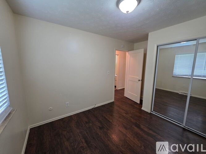 A room with wooden flooring and a sliding glass door.