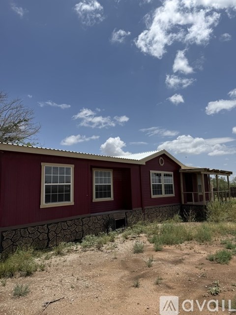 A red house with a stone wall in front.