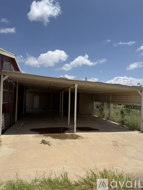 A large, empty, covered outdoor area with a hole in the ground.