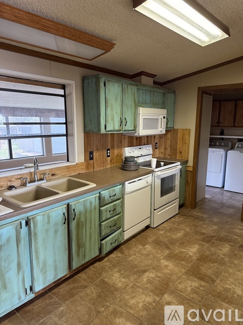 A kitchen with a sink, stove, and oven.