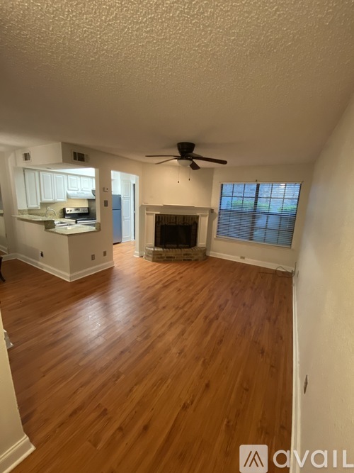 A living room with a fireplace and a ceiling fan.