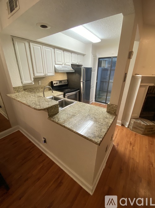 A kitchen with white cabinets and a granite countertop.