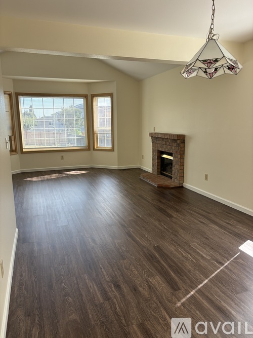 A living room with a fireplace and wood flooring.