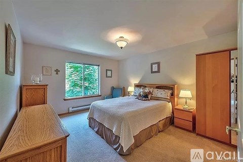 A bedroom with a large bed and a window.