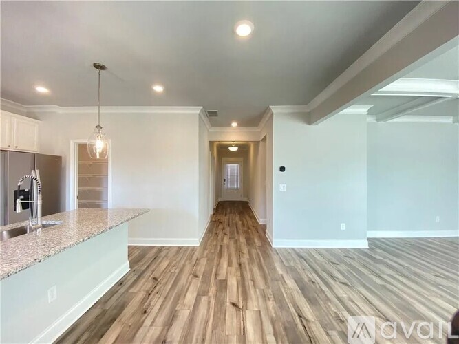 A spacious kitchen with wooden floors and a modern design.