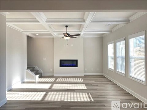 A spacious living room with a television and a staircase.