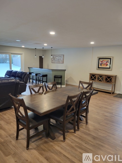 A dining room with a wooden table and chairs.