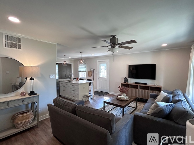 A living room with a grey couch and a ceiling fan.