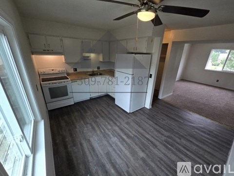 A kitchen with a fan and a countertop with a stove and oven.