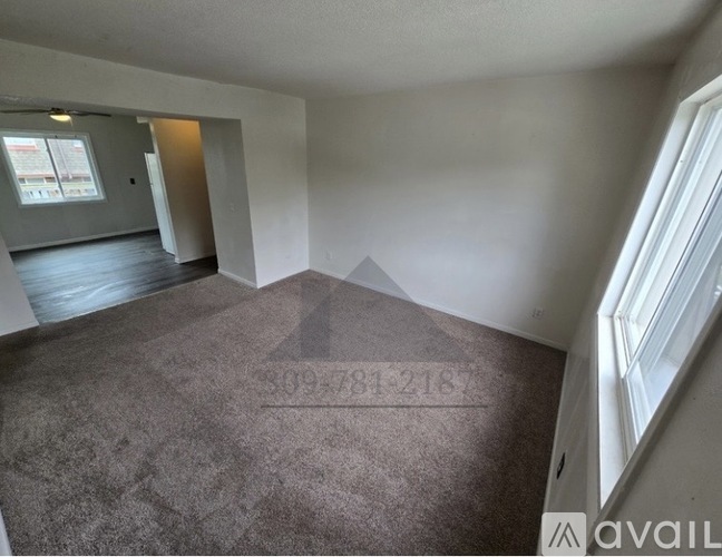 A room with a carpeted floor and a window on the right side.